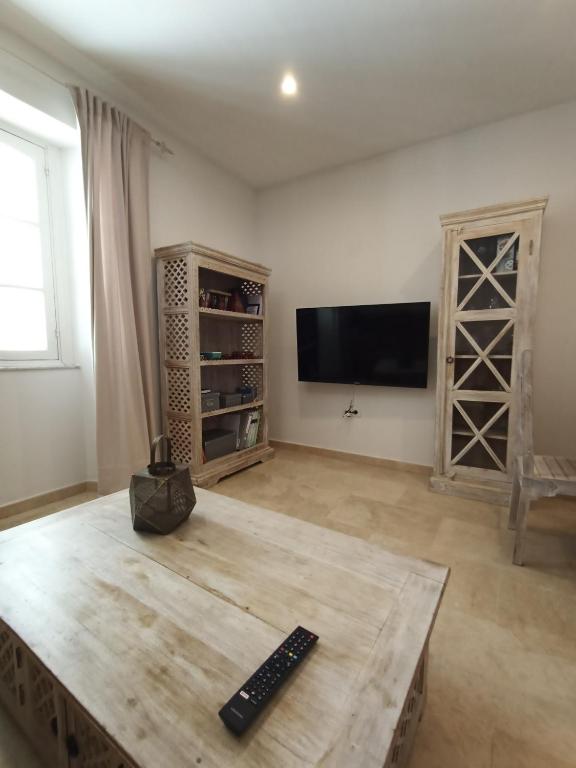 - un salon avec une télévision et une table en bois dans l'établissement Azvalia - Ático Larga 112 - Terraza, à El Puerto de Santa María