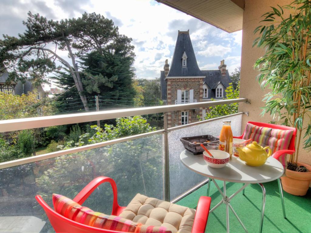 d'un balcon avec une table et des chaises devant une fenêtre. dans l'établissement Apartment Les Jardins de la Malouine by Interhome, à Dinard