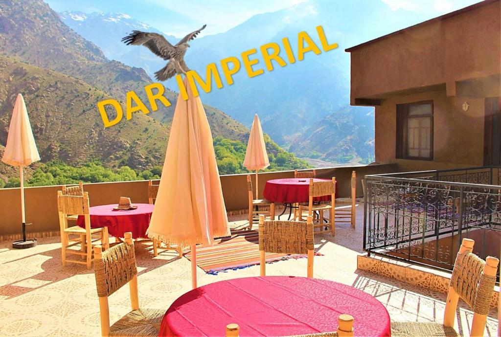 un restaurante con mesas y sombrillas en el balcón en Dar Imperial, en Imlil