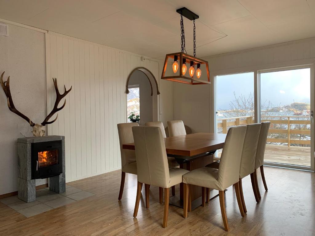een eetkamer met een tafel en een open haard bij Apartments Reine Lofoten in Reine