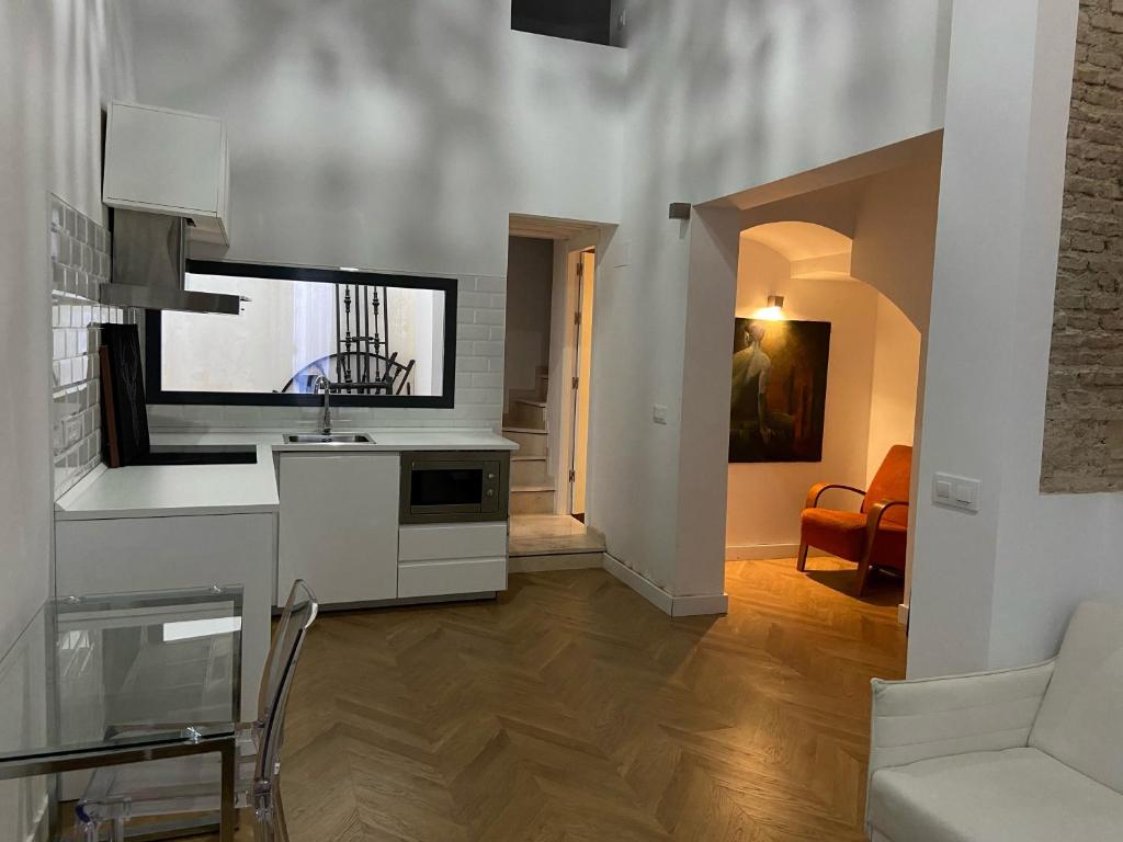 a kitchen with a sink and a living room at CASA ENEKO in Seville