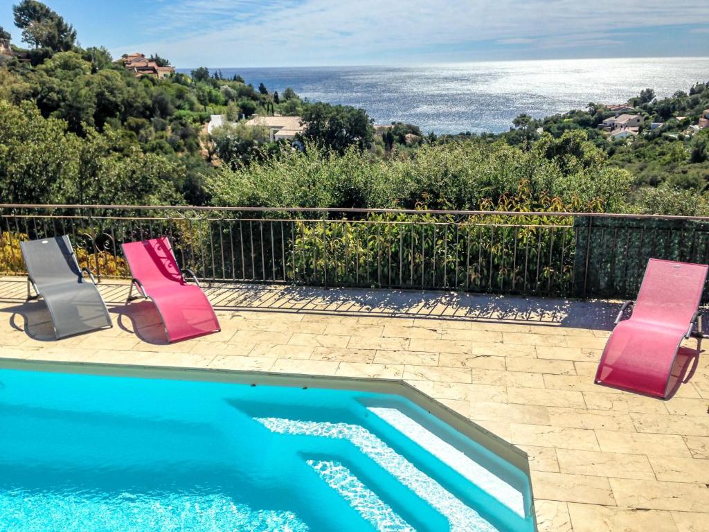 レ・ズィサンブルにあるHoliday Home Villa Serpentines by Interhomeの海の景色を望むプール(椅子2脚付)