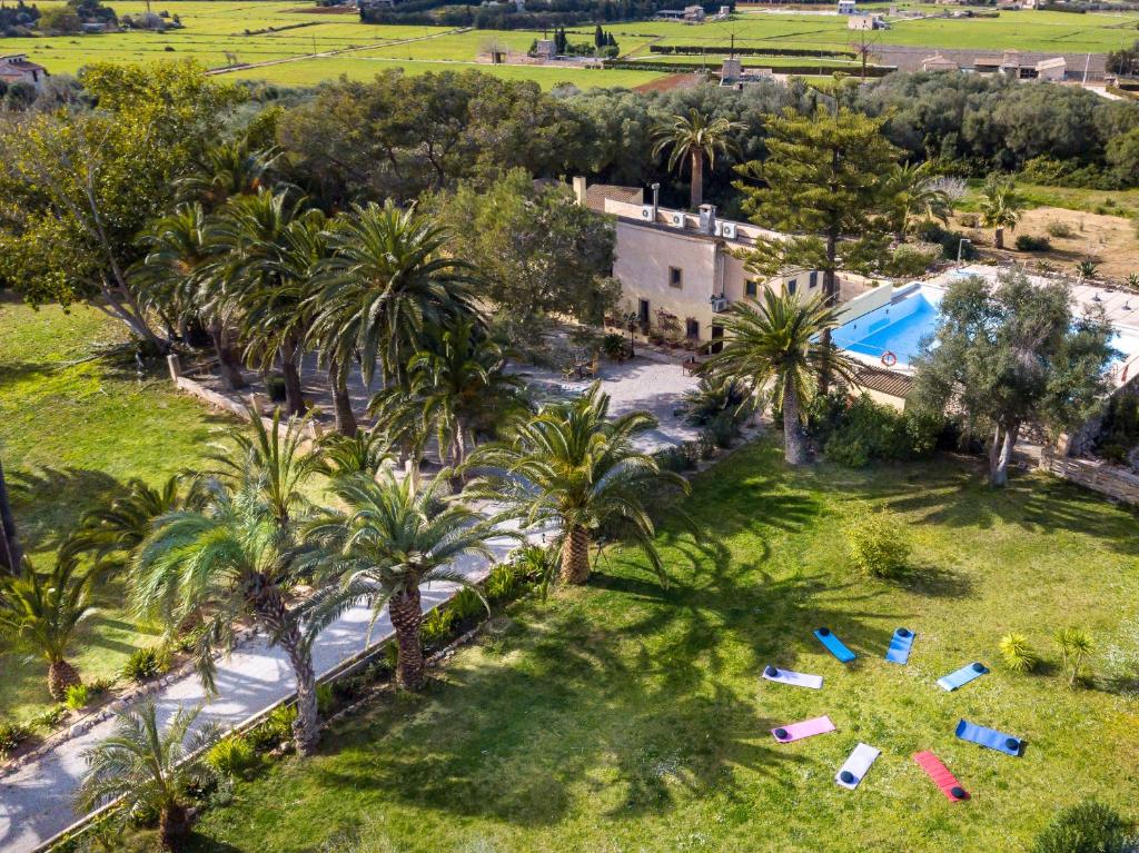 an aerial view of a resort with a pool and palm trees at Finca Hotel Rural Predio Son Serra in Can Picafort