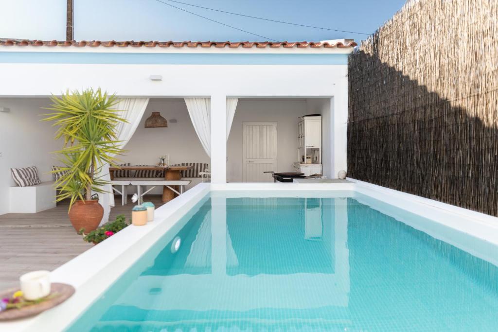 a swimming pool in a backyard with a house at Casa da Avó Pam in Alcáçovas