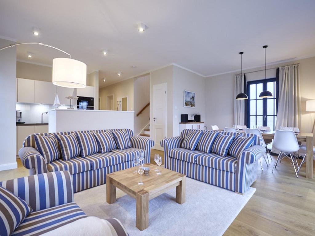 uma sala de estar com dois sofás e uma mesa em Reetland am Meer - Luxus Reetdachvilla mit 3 Schlafzimmern, Sauna und Kamin F15 em Dranske