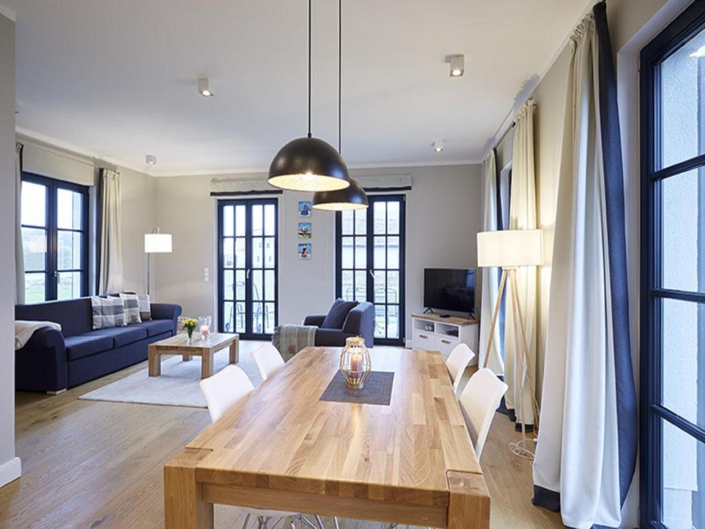 uma sala de estar com uma mesa de madeira e um sofá em Reetland am Meer - Superior Reetdachvilla mit 2 Schlafzimmern F16 em Dranske