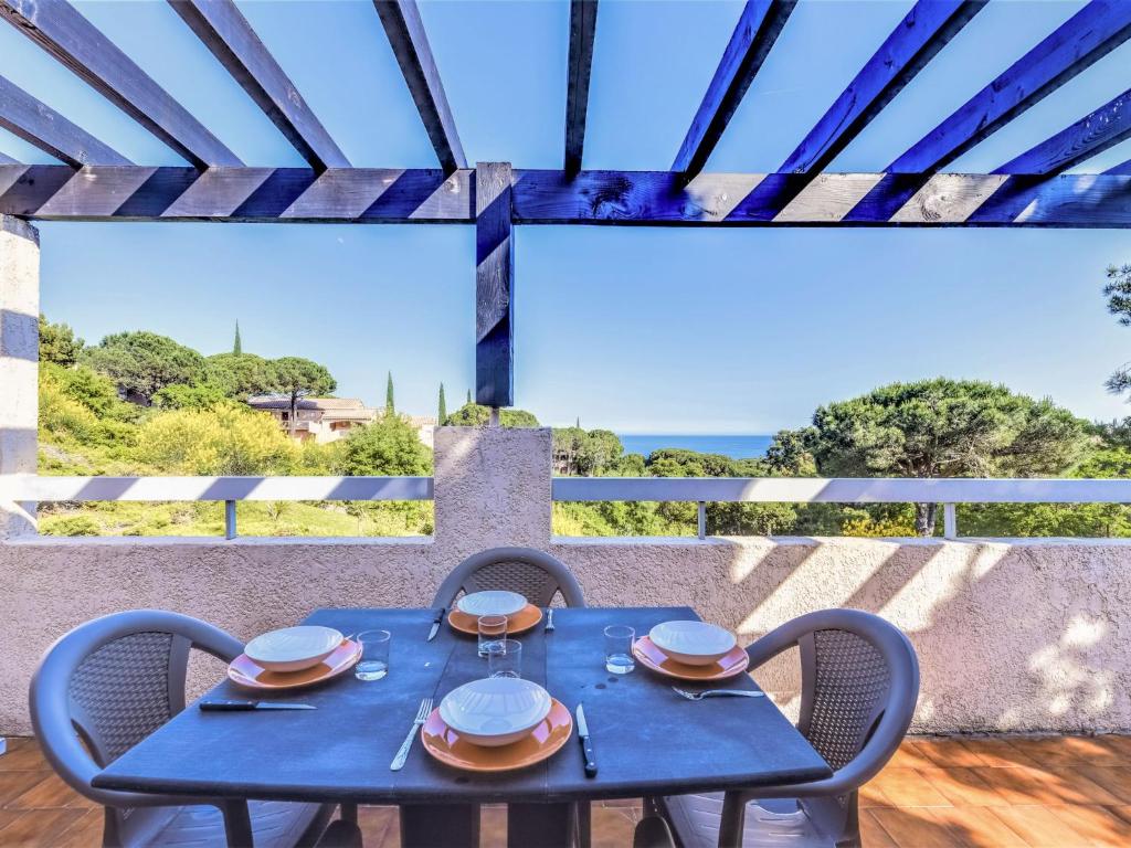 d'une table bleue et de chaises sur un balcon avec vue sur l'océan. dans l'établissement Apartment Les Coteaux de la Nartelle-23 by Interhome, à Sainte-Maxime