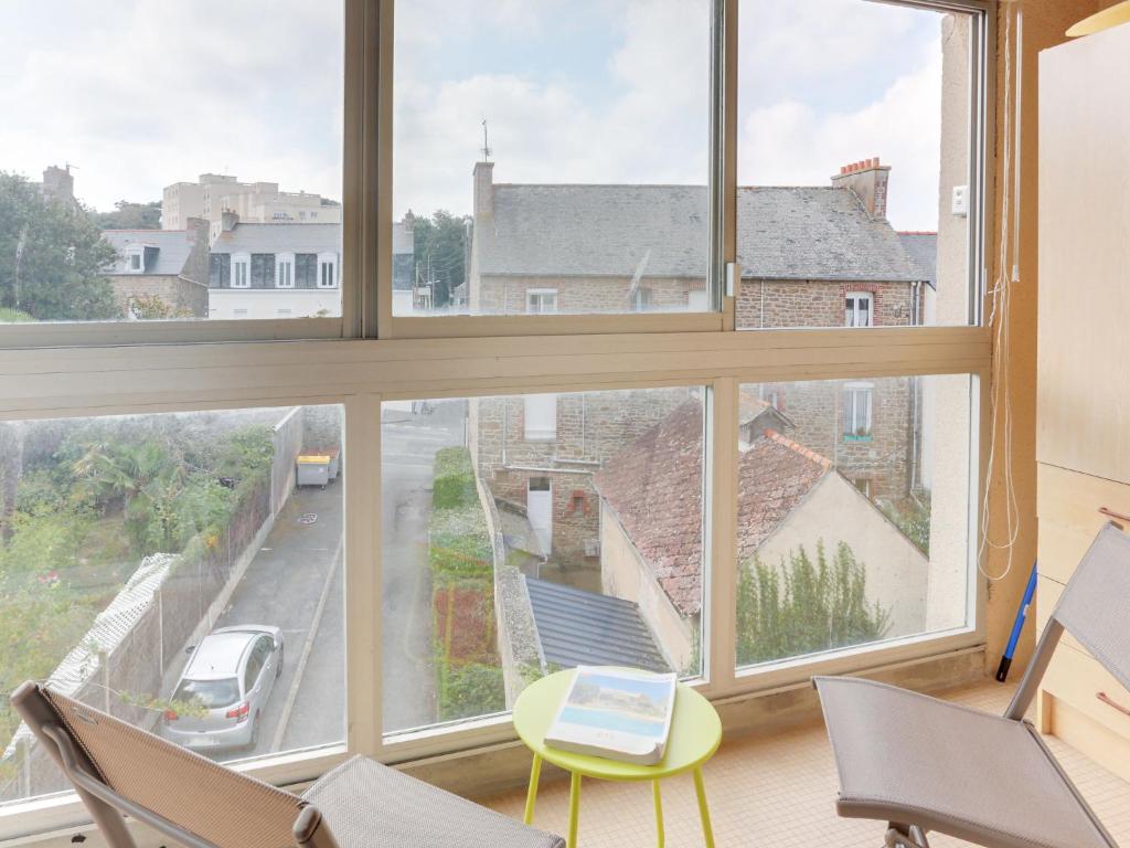 Cette chambre dispose d'une grande fenêtre avec une table et des chaises. dans l'établissement Apartment l'Etang by Interhome, à Saint-Malo