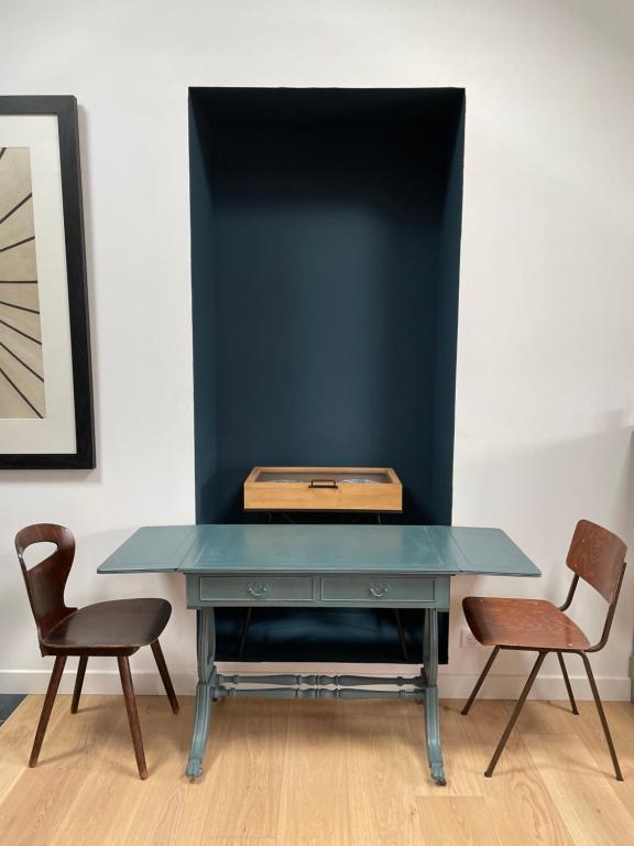 a blue table with two chairs and a box on top at Kermaria Studio Suite in Pont-Aven