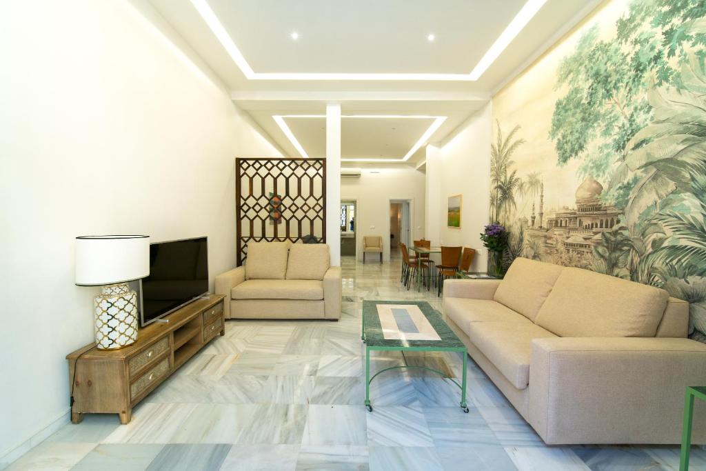 uma sala de estar com um sofá e uma televisão em Arco Macarena Lofts em Sevilha