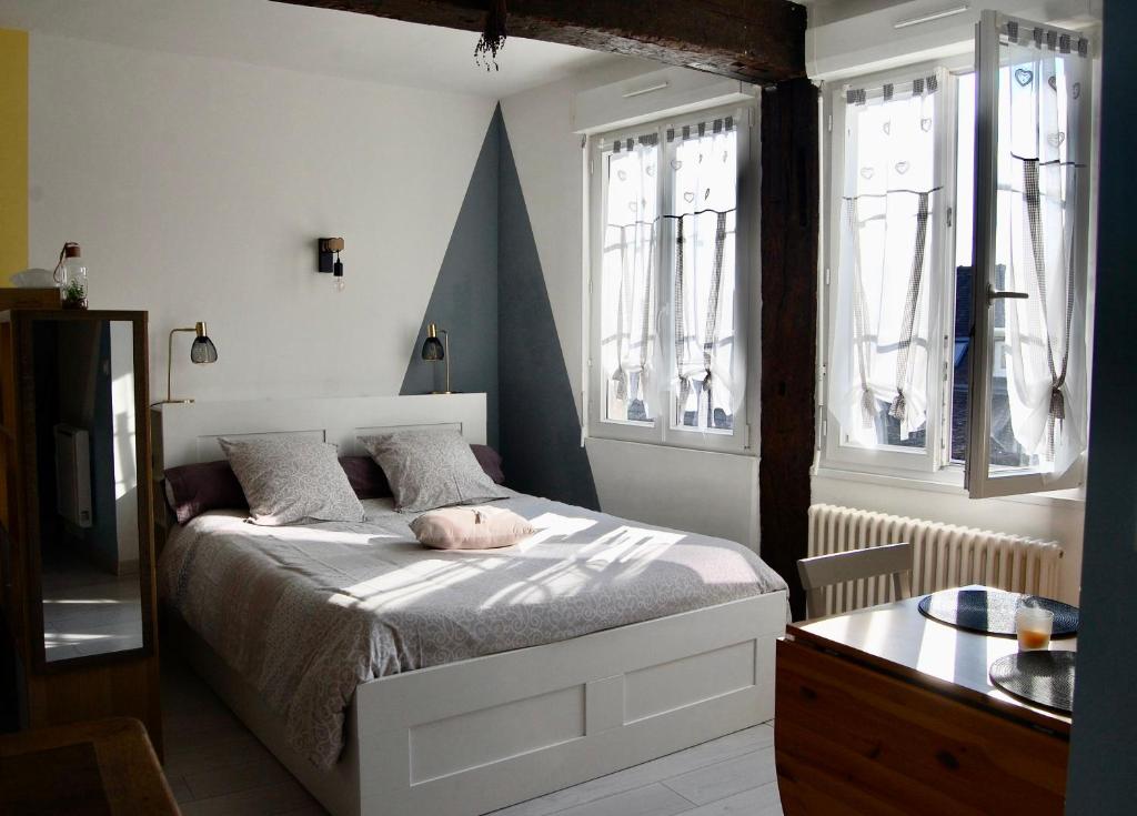 1 dormitorio con 1 cama y 2 ventanas en L IMPREVU, en Chartres