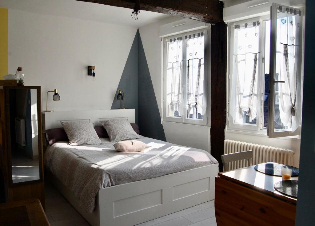 a bedroom with a bed and two windows at L IMPREVU in Chartres