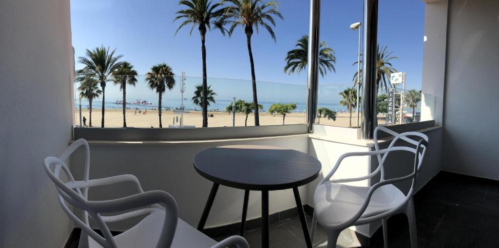 een tafel en stoelen op een balkon met uitzicht op het strand bij For a Stay Roesmar in Cambrils
