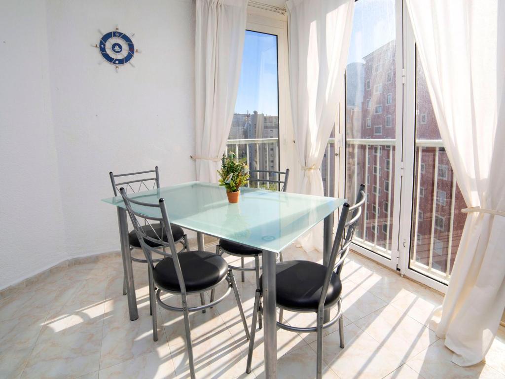 Una mesa y sillas en una habitación con una ventana grande. en Apartment Atlantico-2 by Interhome, en Calpe
