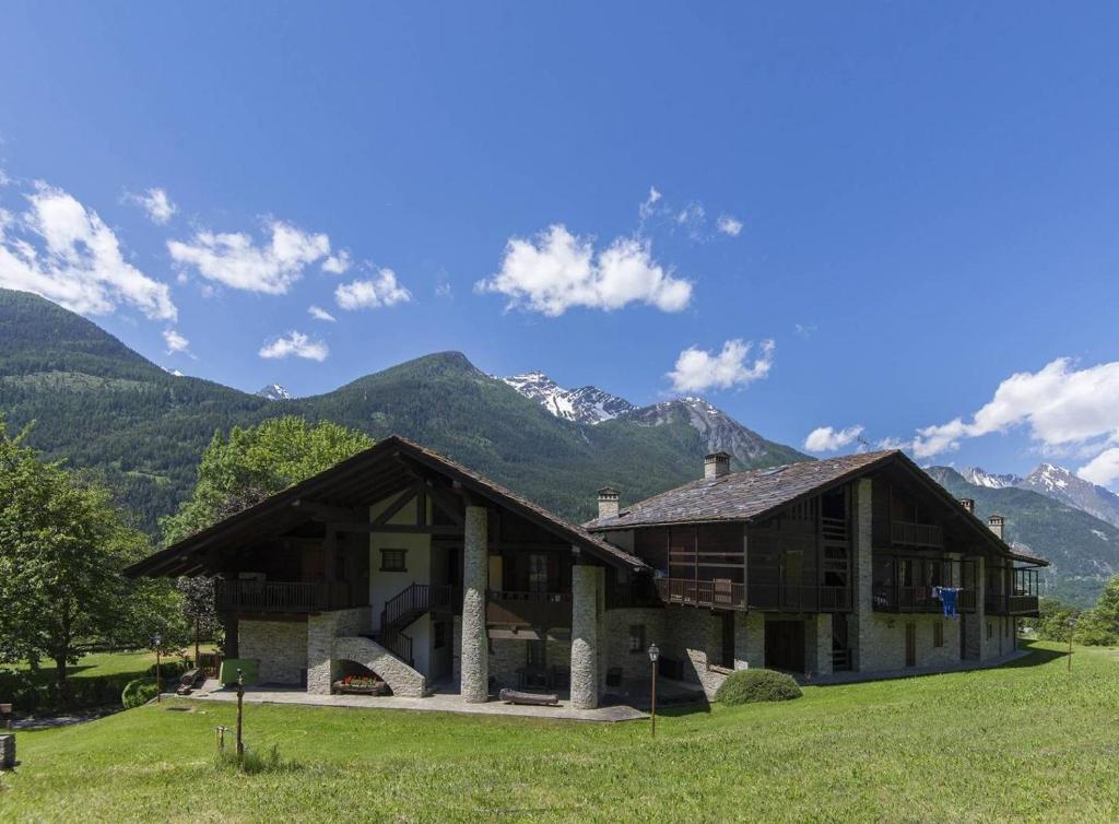 uma casa num campo com montanhas ao fundo em Vacanze a La Salle em La Salle