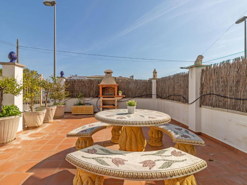 a patio with a table and two benches at Apartment Sol i Canal by Interhome in Empuriabrava
