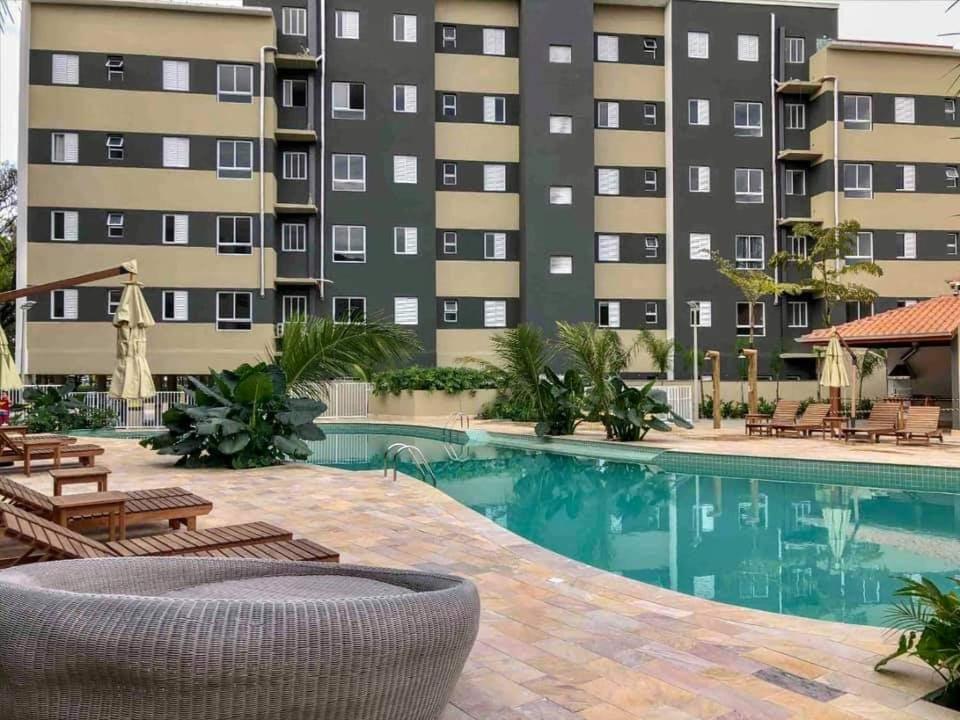 una piscina en un hotel con sillas y un edificio en Resort Palmeiras 2 Ubatuba en Ubatuba