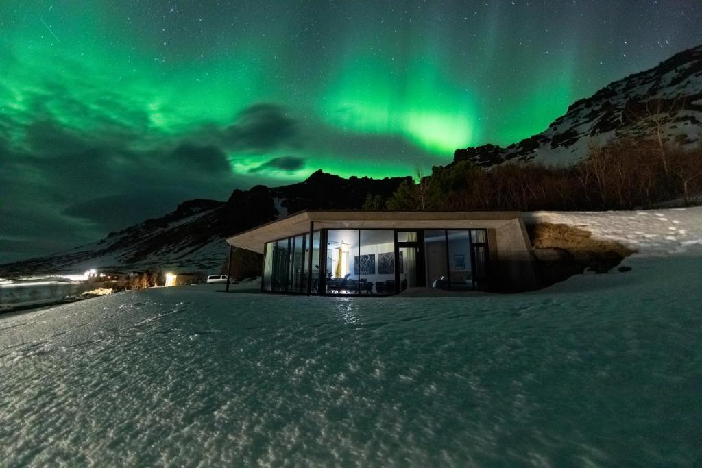 a house under the northern lights in the snow at Klettasel in Hof