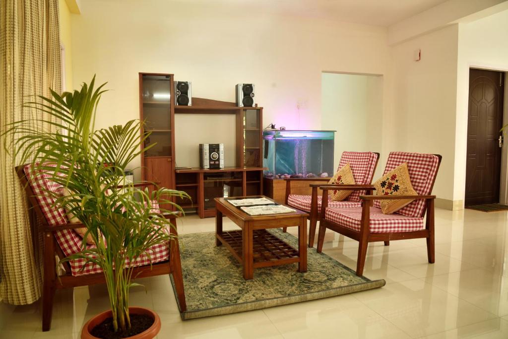 a living room with a table and chairs and a fish tank at GRUHAM SOJOURN HOMESTAY in Guwahati