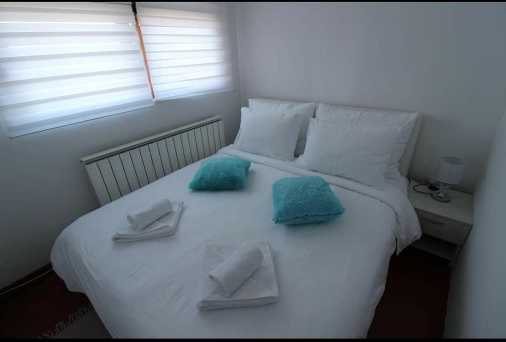 a white bed with blue towels on top of it at Pegaz009**** in Vrnjačka Banja