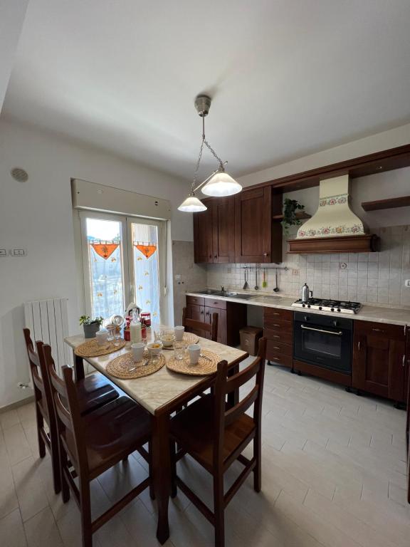 a kitchen with a wooden table and chairs and a kitchen with a stove at La Torretta in LʼAquila