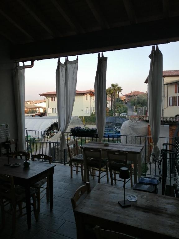 a patio with tables and chairs and a view of a building at Little Family in Salò