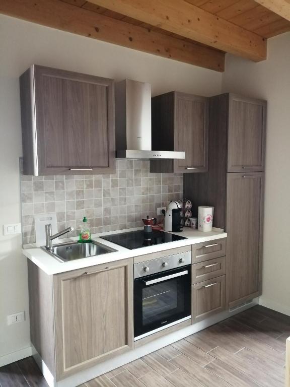 kuchnia ze zlewem i kuchenką górny piekarnik w obiekcie Little Family w mieście Salò
