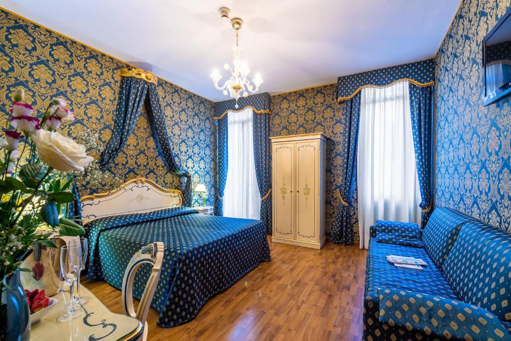 a blue bedroom with a bed and a couch at Al Gazzettino in Venice