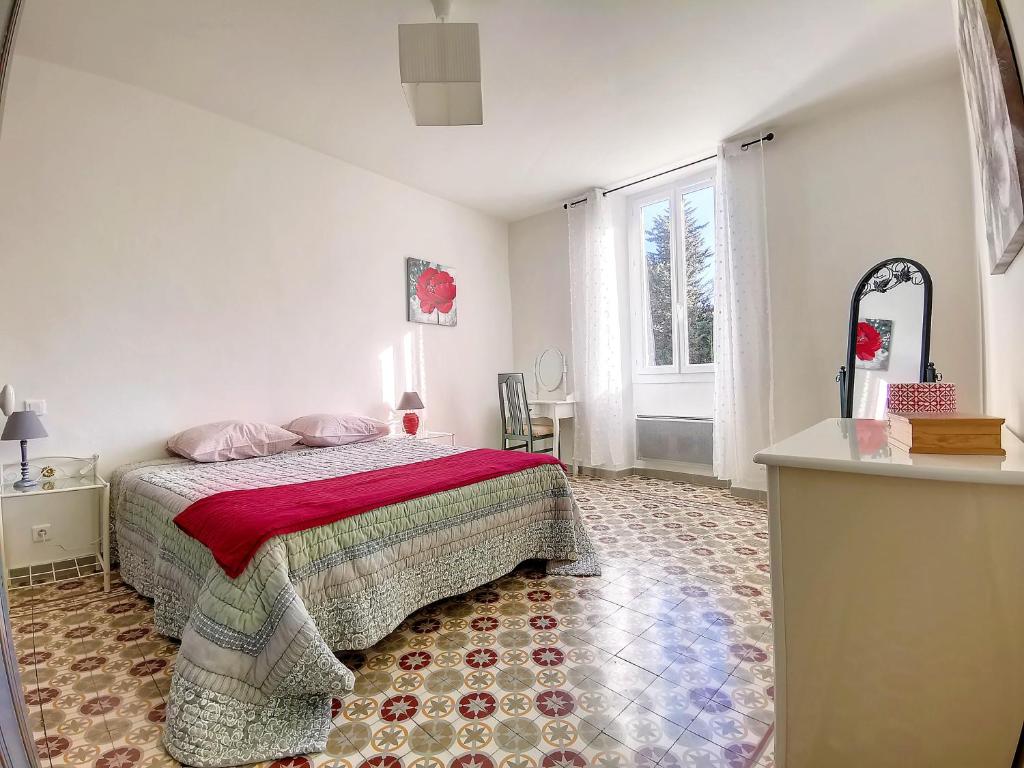 a bedroom with a bed and a large window at Mas Jeannot 8 personnes in Noves