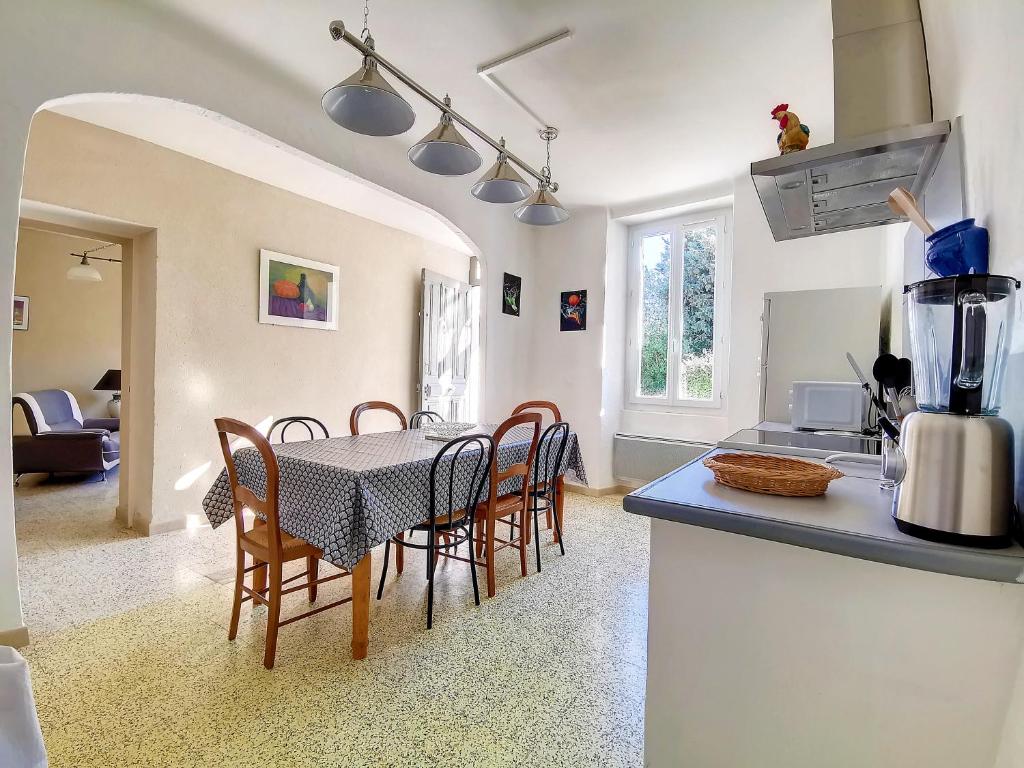 a kitchen and dining room with a table and chairs at Mas Jeannot 8 personnes in Noves