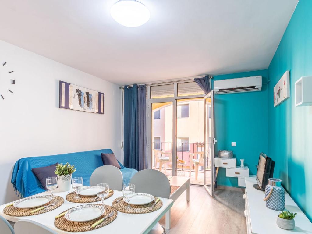 a living room with a table and a blue couch at Apartment Gran Reserva-31 by Interhome in Empuriabrava