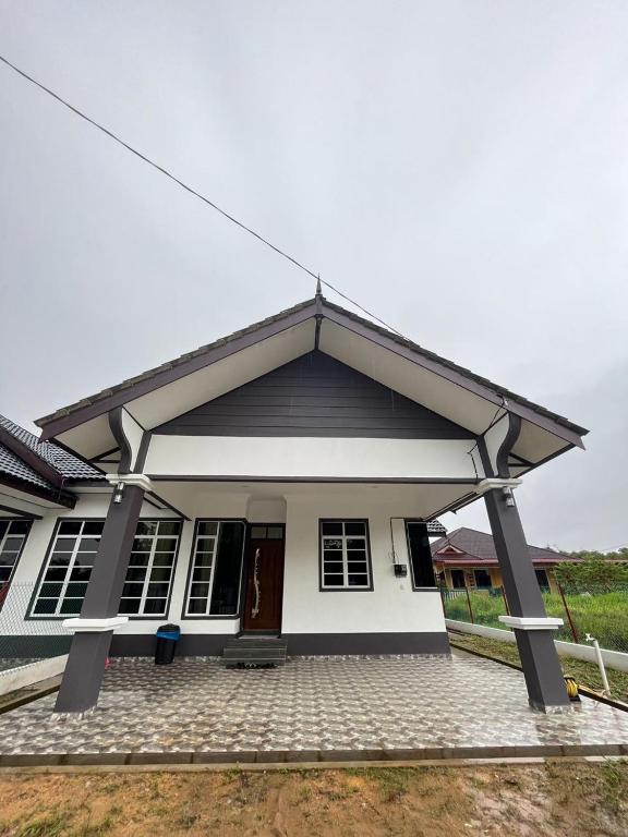 a small white house with a black roof at Sofea's Homestay in Kuala Terengganu