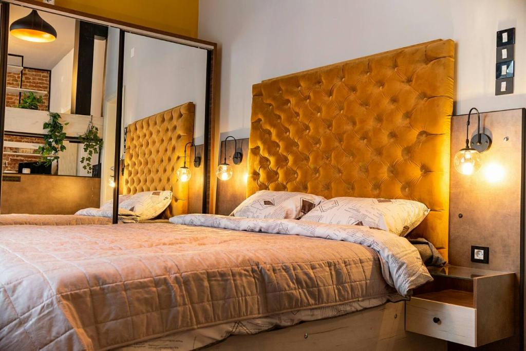 ein Schlafzimmer mit einem großen Bett und einem großen Spiegel in der Unterkunft MariaApartments in Bitola