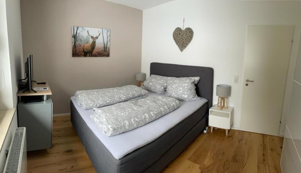 ein Schlafzimmer mit einem Bett und einem Bild eines Hirsches in der Unterkunft Zeit für Dich am Bergelchen, Winterberg in Winterberg