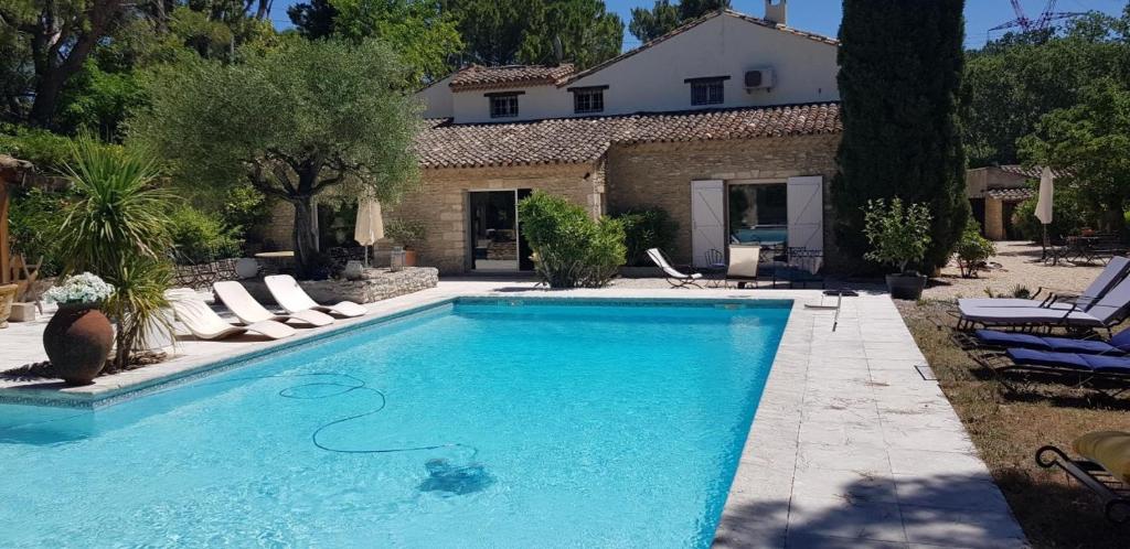 une piscine devant une maison dans l'établissement Le Mas des Cosme, à Aramon