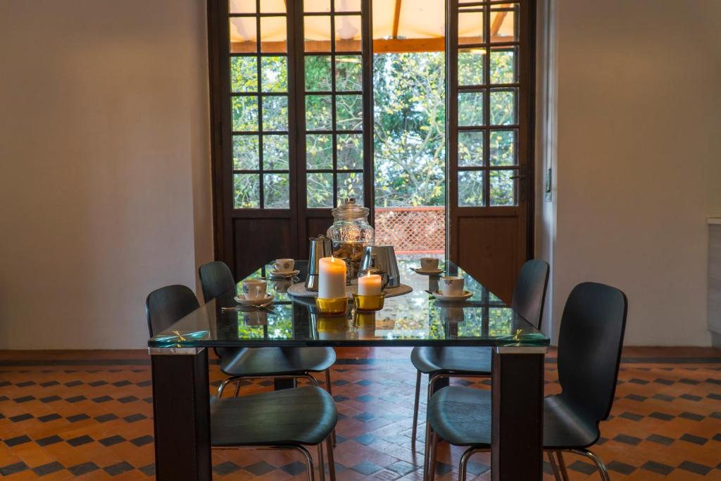 comedor con mesa de cristal y sillas en Villa I Tigli Appartamenti en Campiglia Marittima
