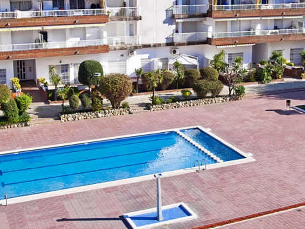 an empty swimming pool in front of a building at APCOSTAS Lotus in Blanes