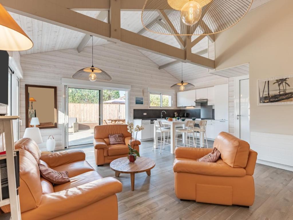 a living room with two couches and a kitchen at Holiday Home Villa Horizon by Interhome in Lacanau-Océan