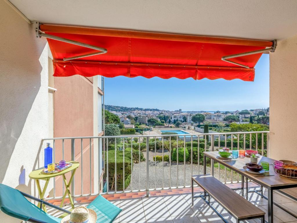 - un balcon avec une table, des chaises et un parasol rouge dans l'établissement Apartment Les Côteaux du Préconil-3 by Interhome, à Sainte-Maxime