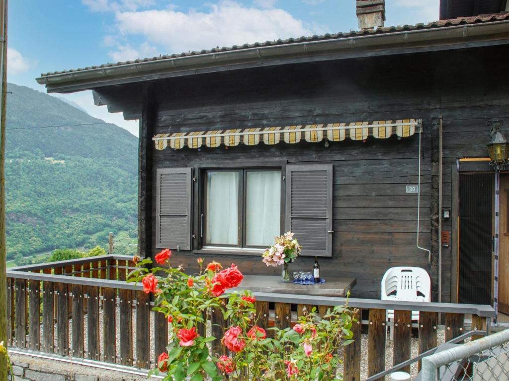 een huis met een balkon met een tafel en stoelen bij Holiday Home Casa Pina by Interhome in Malvaglia