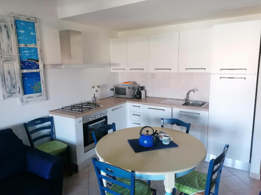 瓦雷多利亚Sardamare Apartments Appartamenti La Ciaccia的厨房配有桌椅和水槽。