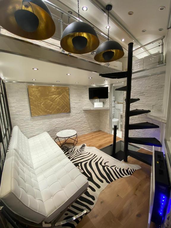 - un salon avec un canapé blanc et un escalier dans l'établissement Superbe Triplex au Coeur de Montorgueil, à Paris