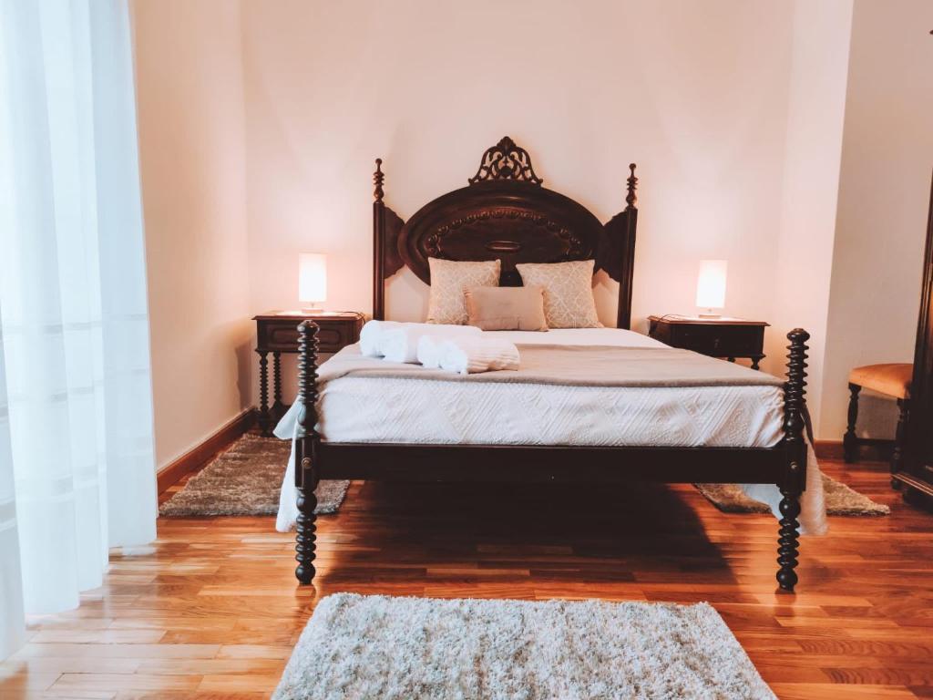 ein Schlafzimmer mit einem Bett mit zwei Nachttischen und zwei Lampen in der Unterkunft O Palheiro in Bragança