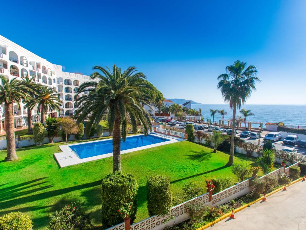 een uitzicht op een resort met een zwembad en palmbomen bij Apartment Carabeo by Interhome in Nerja