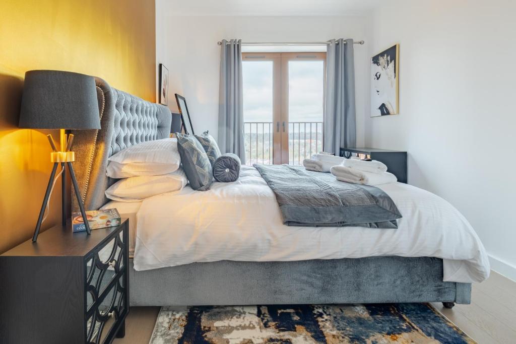 Un dormitorio con una cama grande y una ventana. en LillyRose Serviced Apartments - St Albans City Centre, Parking, en Saint Albans