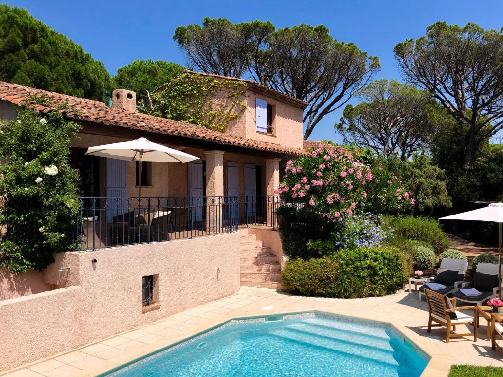 a villa with a swimming pool in front of a house at Villa Golf Azur in Saint-Raphaël