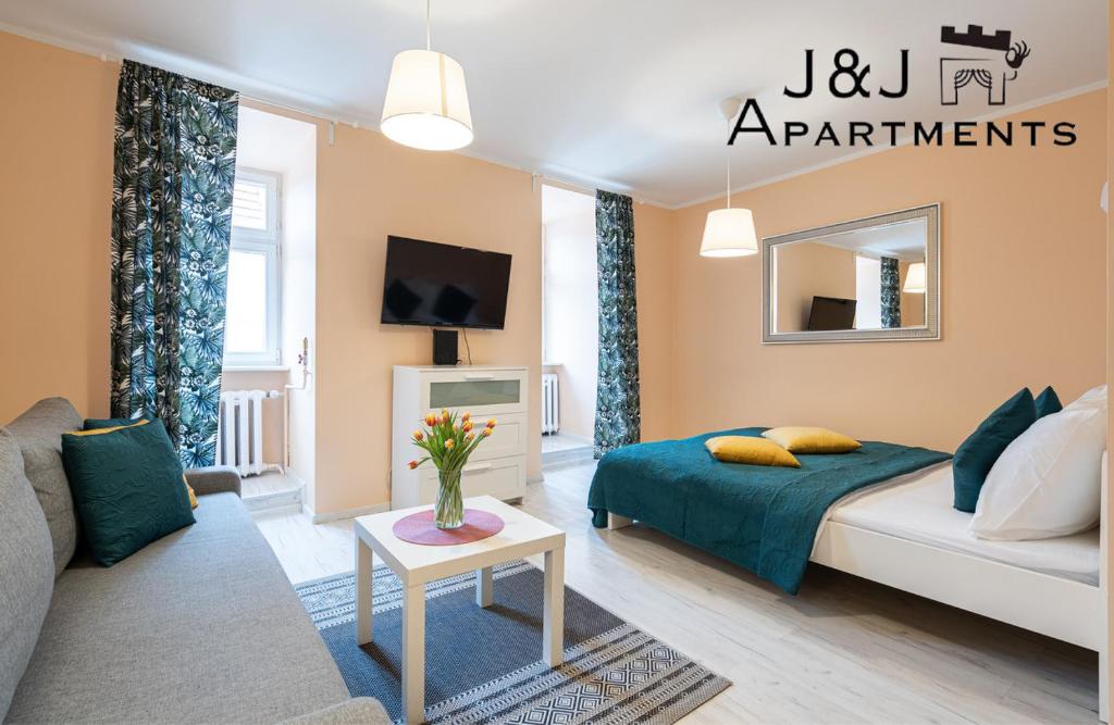a living room with a bed and a couch at J&J Apartments - Szczytna 1, Apartament 10 in Toruń