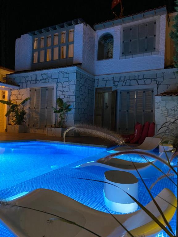 una grande piscina di fronte a una casa di notte di My Dream Alaçatı ad Alaçatı