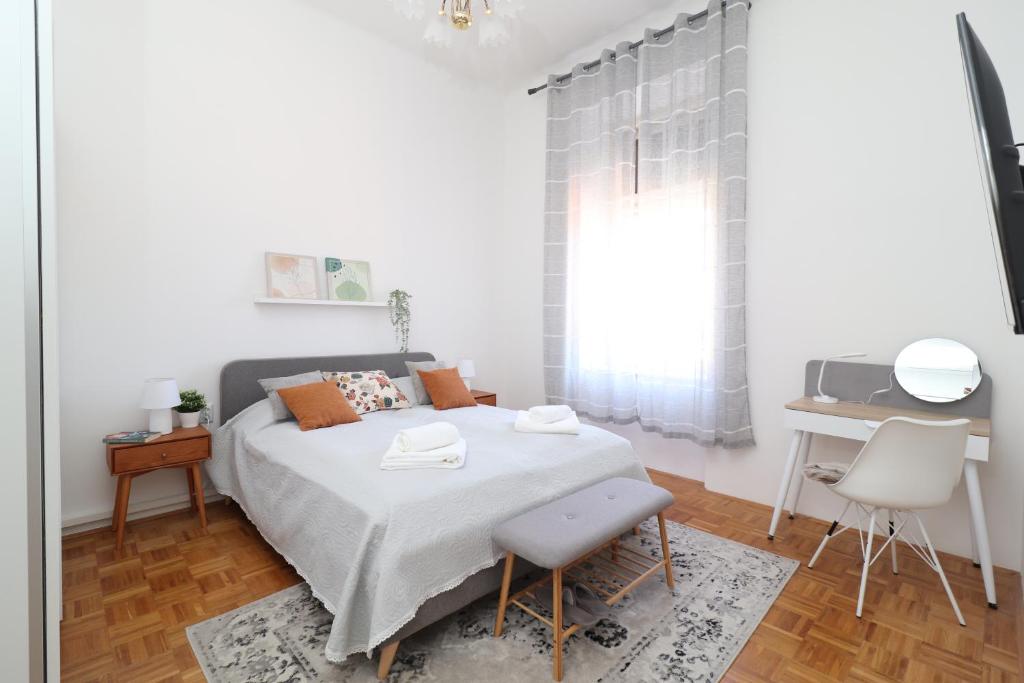 1 dormitorio con cama, escritorio y ventana en Apartment villa Blaschki, en Opatija