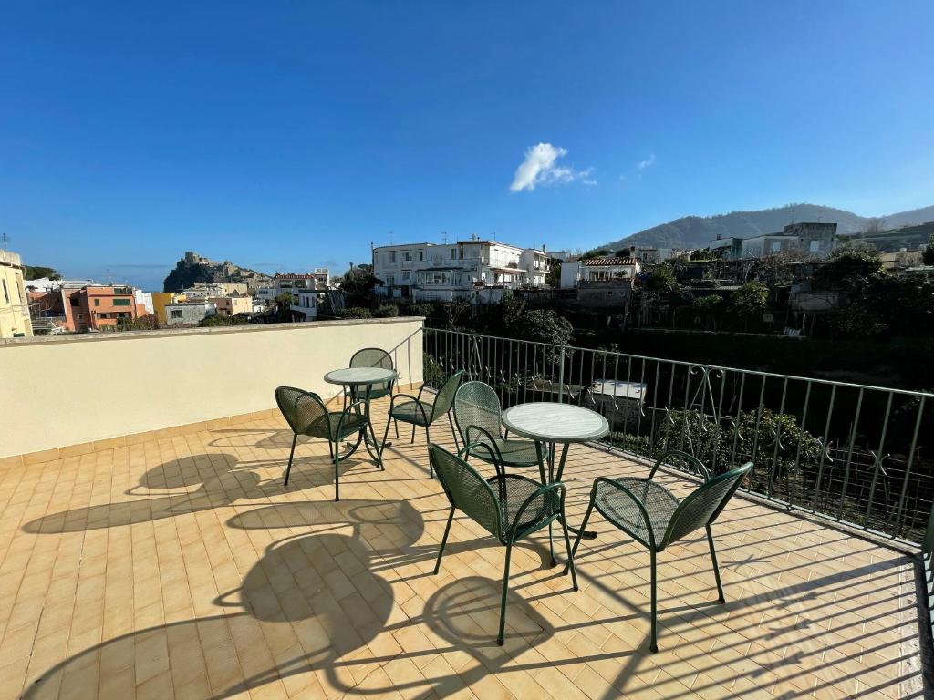 patio z krzesłami i stołami na balkonie w obiekcie Villa dei Sogni - Aparthotel Ischia Ponte w mieście Ischia